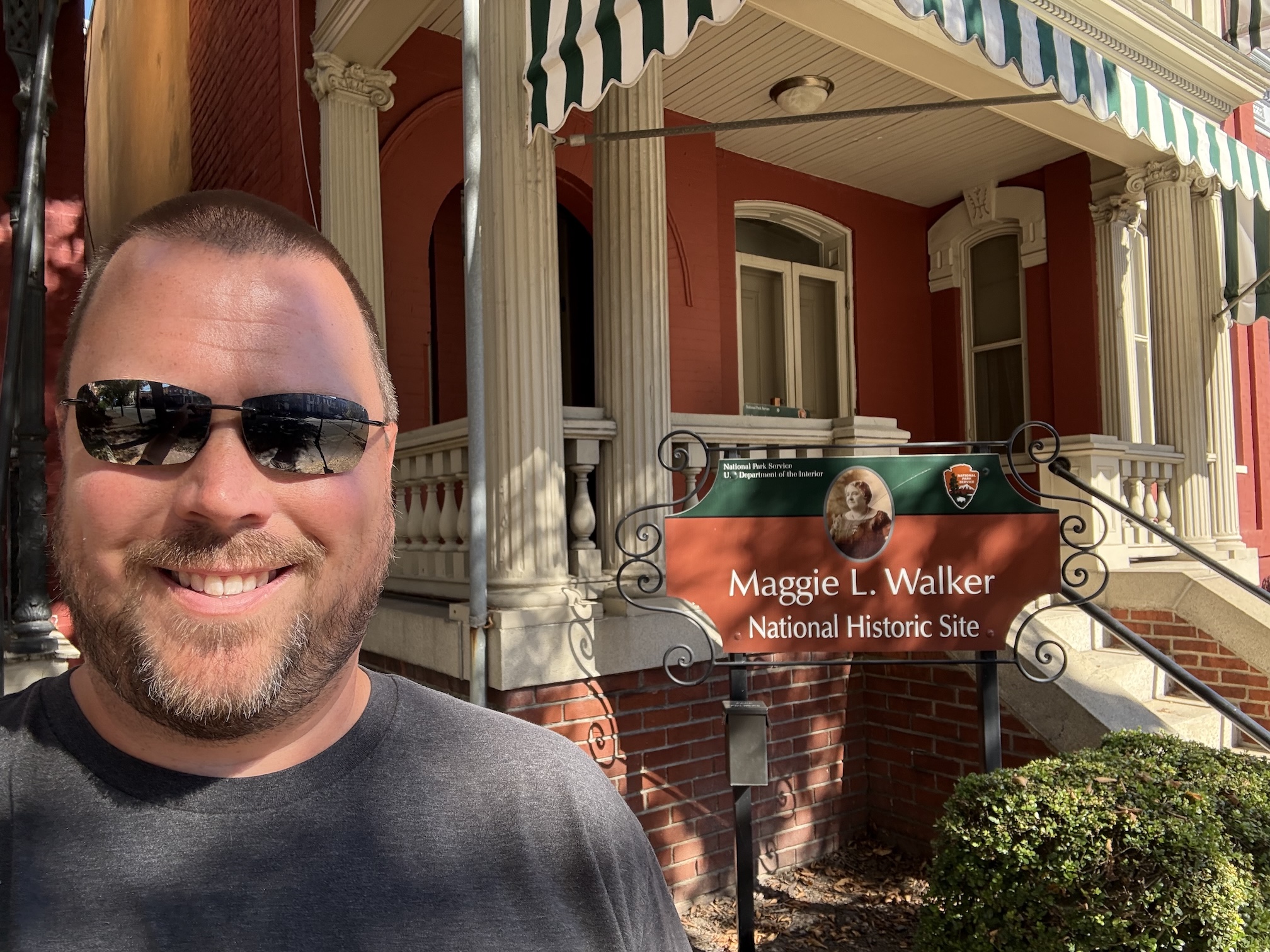 Me in front of the Maggie L. Walker National Historic Site sign and her house